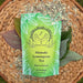 Waimea Herb Company Mamaki Lemongrass Tea package on a woven mat with tea leaves.