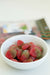 White bowl filled with red and green gummy candies on a blurred background